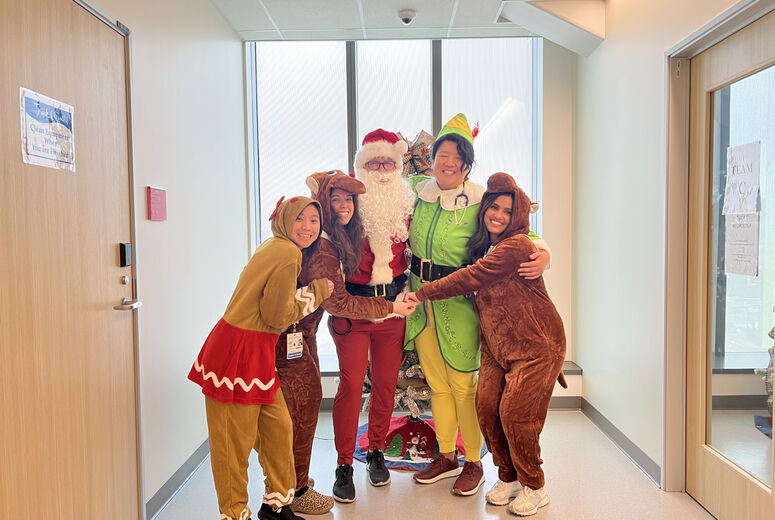 residents dressed as Santa and his helpers taking a photo 