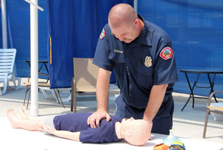 Fireman demonstrating CPR on dummy