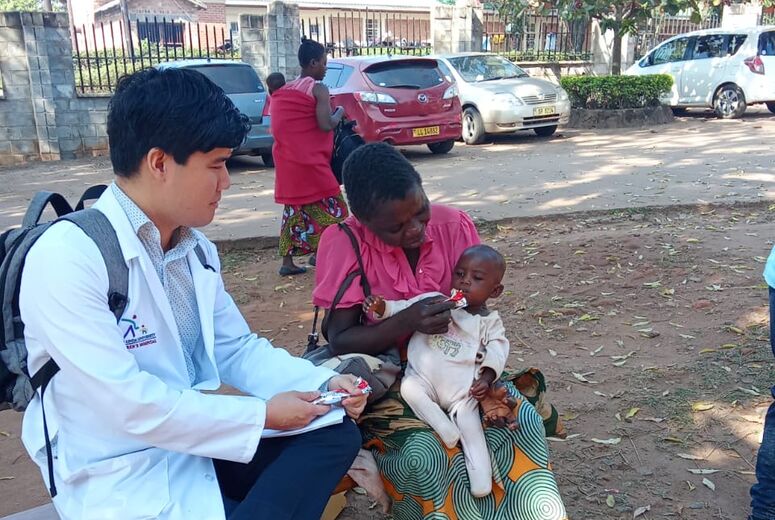 DR. ZHENG CARING FOR A YOUNG PATIENT DURING HIS INTERNATIONAL ROTATION IN MALAWI
