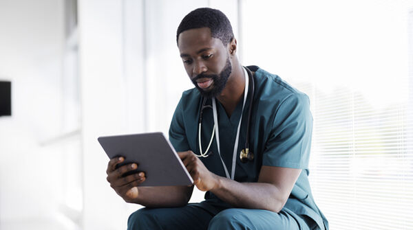 Male doctor reviewing tablet content