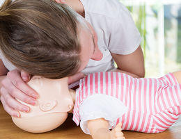 woman in CPR class practicing on "fake" baby