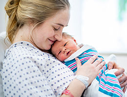 Mother cradling baby after birth