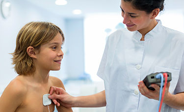 Boy receiving non-invasive cardiology treatment 