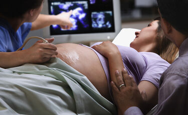 nursing and pregnant mother looking at monitor