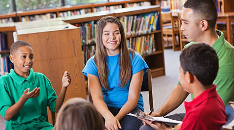 Children sitting in a circle talking with an adult