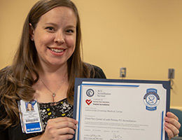 RN holding up certificate of recognition